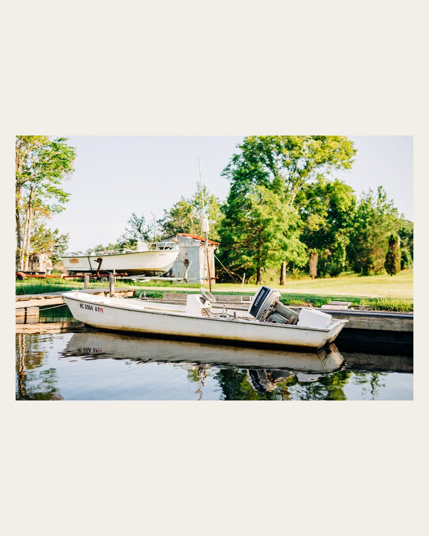 A boat at a dock on a cream 4:5 border